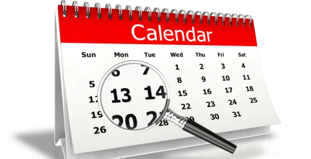 Calendario de pared con una lupa sobre los días del mes